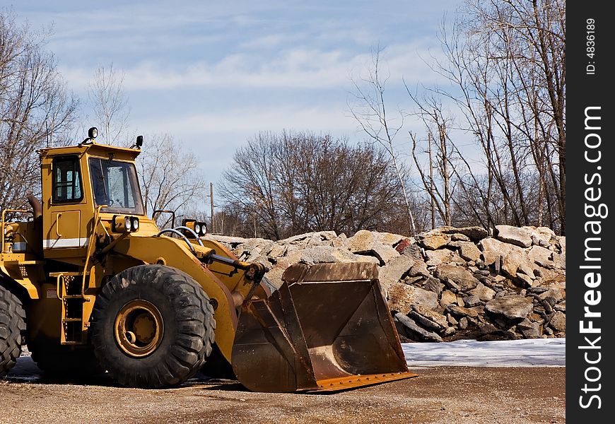 Front loader near a pile of large stones