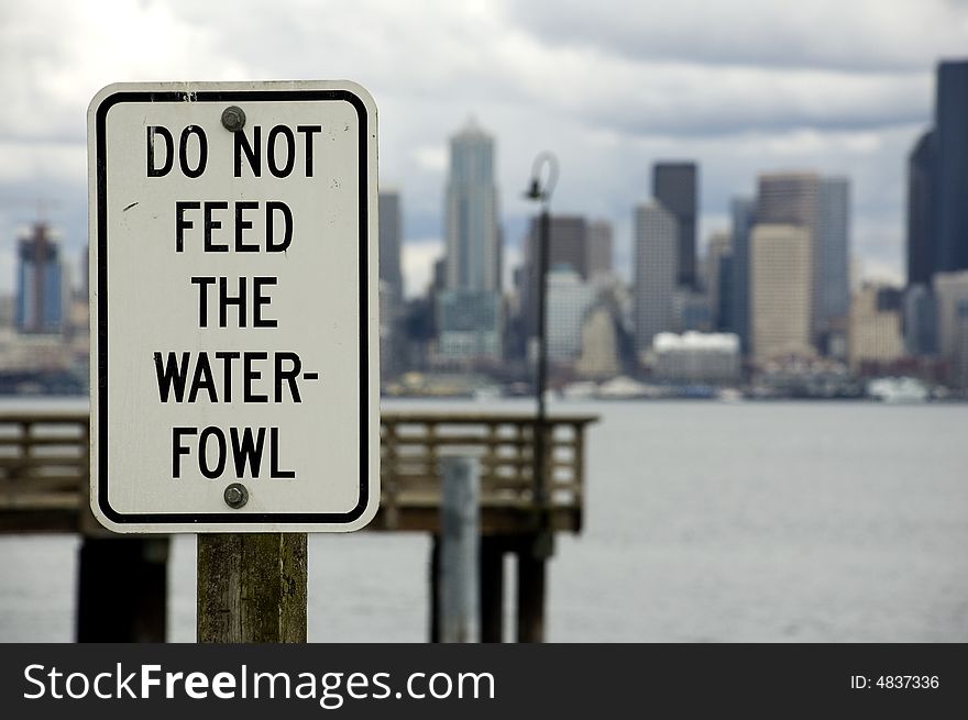 A sign on Alki across from downtown Seattle admonishing tourists not to feed the waterfowl. A sign on Alki across from downtown Seattle admonishing tourists not to feed the waterfowl.