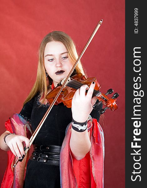 The young woman with gothic cosmetics plays on a violin. The young woman with gothic cosmetics plays on a violin.