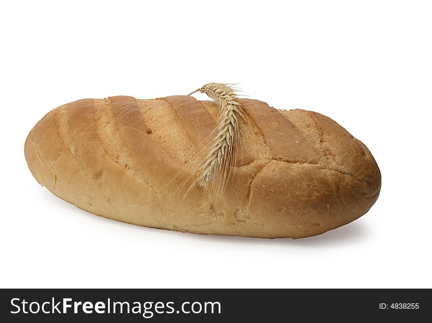 Wheat ear lying on fresh-baked white bread on white background. Wheat ear lying on fresh-baked white bread on white background