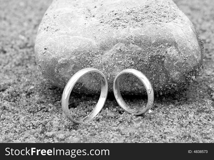 Two wedding rings on the sand