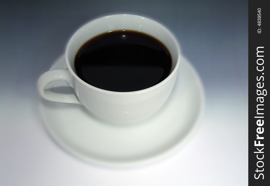 The cup of the black coffee on the white saucer. The cup of the black coffee on the white saucer.