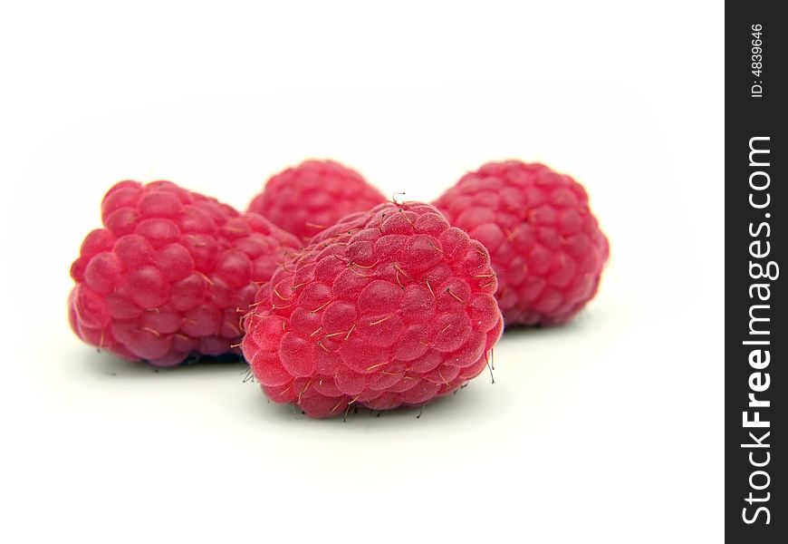 Four mature raspberries on the white background