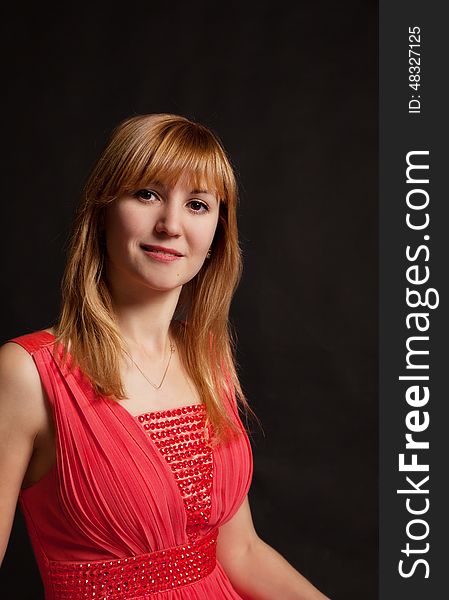 Portrait of a beautiful young woman in a red dress