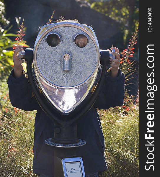 Girl using a telescope looking towards the camera. Girl using a telescope looking towards the camera