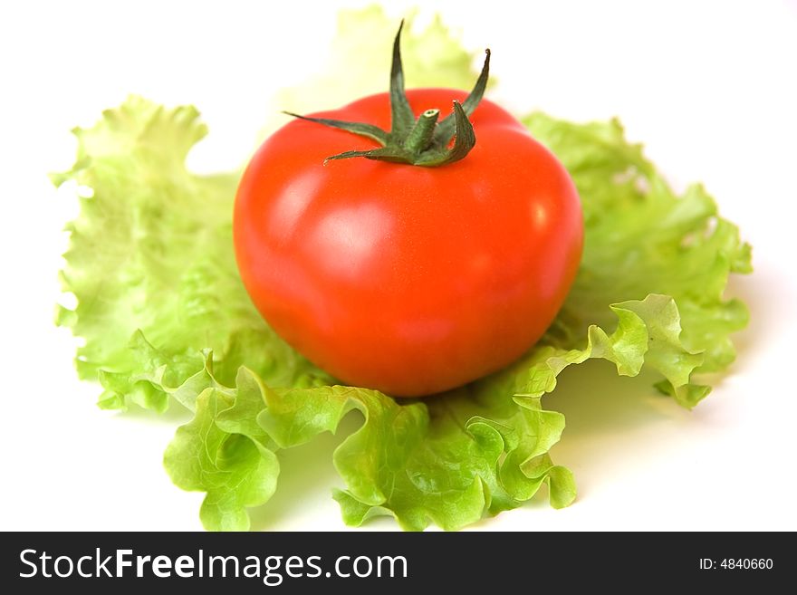 A tomato on a list of a salad. A tomato on a list of a salad