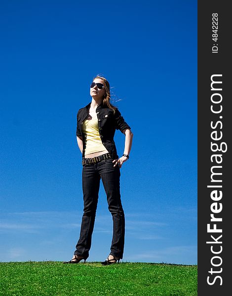 The young attractive girl on a background of the blue sky