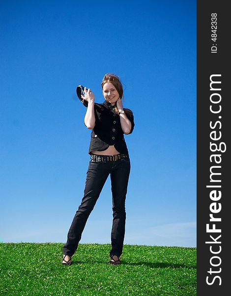 The young attractive girl with headphones on a background of the blue sky