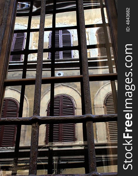 Building reflected in a window with bars over it in Venice Italy. Building reflected in a window with bars over it in Venice Italy