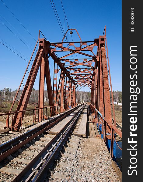 Rail tracks on the bridge, forest on the other river bank. Rail tracks on the bridge, forest on the other river bank