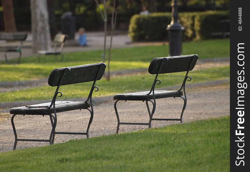 Two lonely park benches in a public garden in Florence. Two lonely park benches in a public garden in Florence