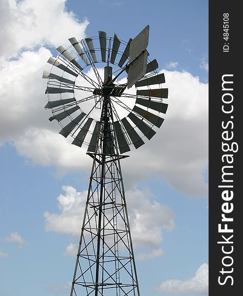 Windmill against an azure sky with a cloudscape. Derby, Western Australia, Australia