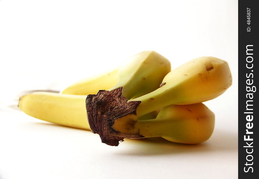 Image of a bunch of yellow bananas, laying on their side.  Focus is on stems.  Horizontal orientation. Image of a bunch of yellow bananas, laying on their side.  Focus is on stems.  Horizontal orientation.