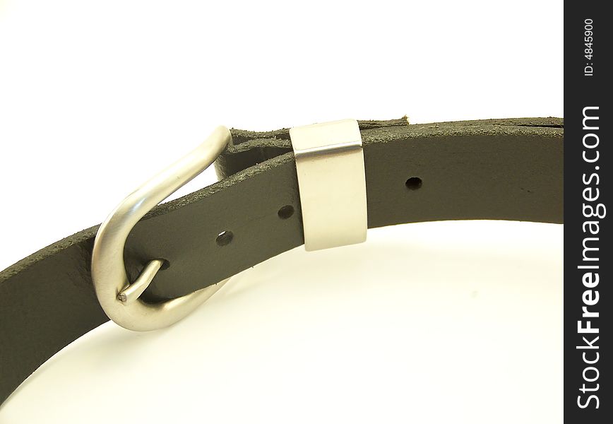 Image of a black leather belt with metal buckle, laying on its side and curving through the frame.  Horizontal orientation. Image of a black leather belt with metal buckle, laying on its side and curving through the frame.  Horizontal orientation.