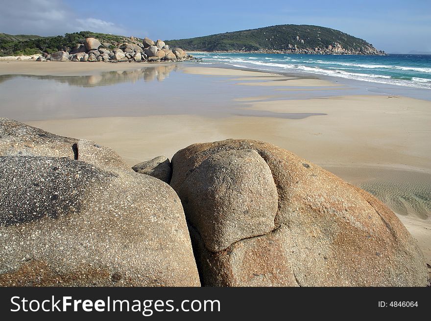 Sandy beach against huge stones