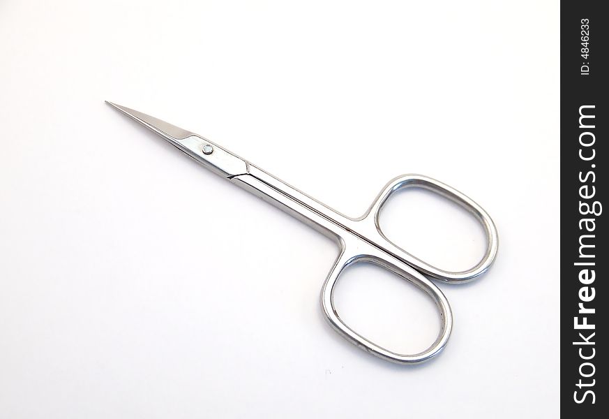 Image of a pair of bright metal manicure scissors.  Horizontal orientation.