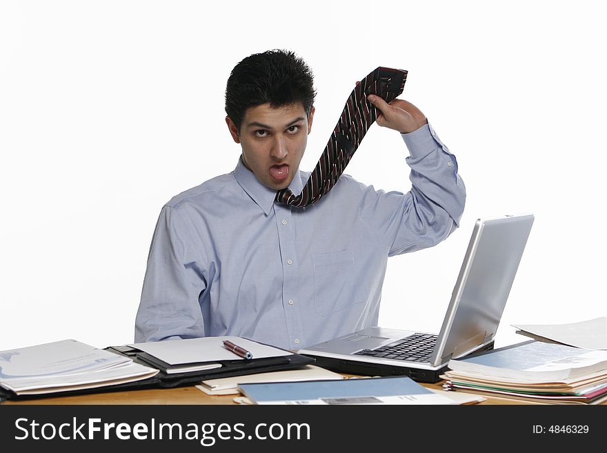 Fed up business man working at his laptop. Isolated against a white background. Fed up business man working at his laptop. Isolated against a white background