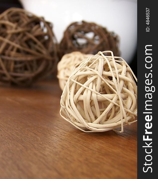Image of vine decorations on a wooden surface, with white bowl in the background.  Vertical orientation.