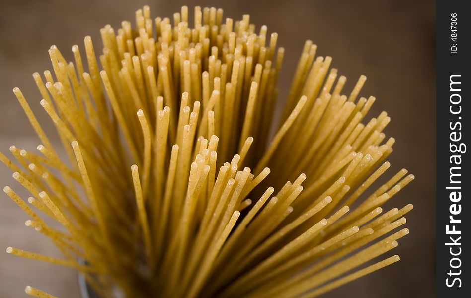 An image of uncooked wheat spaghetti. An image of uncooked wheat spaghetti
