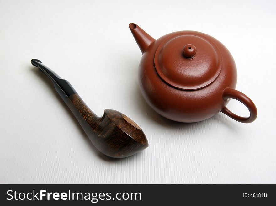 Tobacco pipe and Teapot on white background.