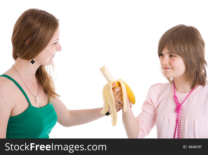 The two young attractive girl with a banana isolated on a white background. The two young attractive girl with a banana isolated on a white background