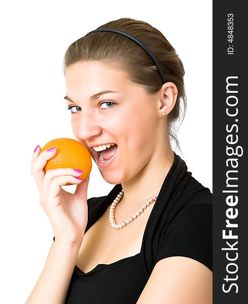 Beautiful girl in a black evening dress bites an orange isolated on a white background. Beautiful girl in a black evening dress bites an orange isolated on a white background