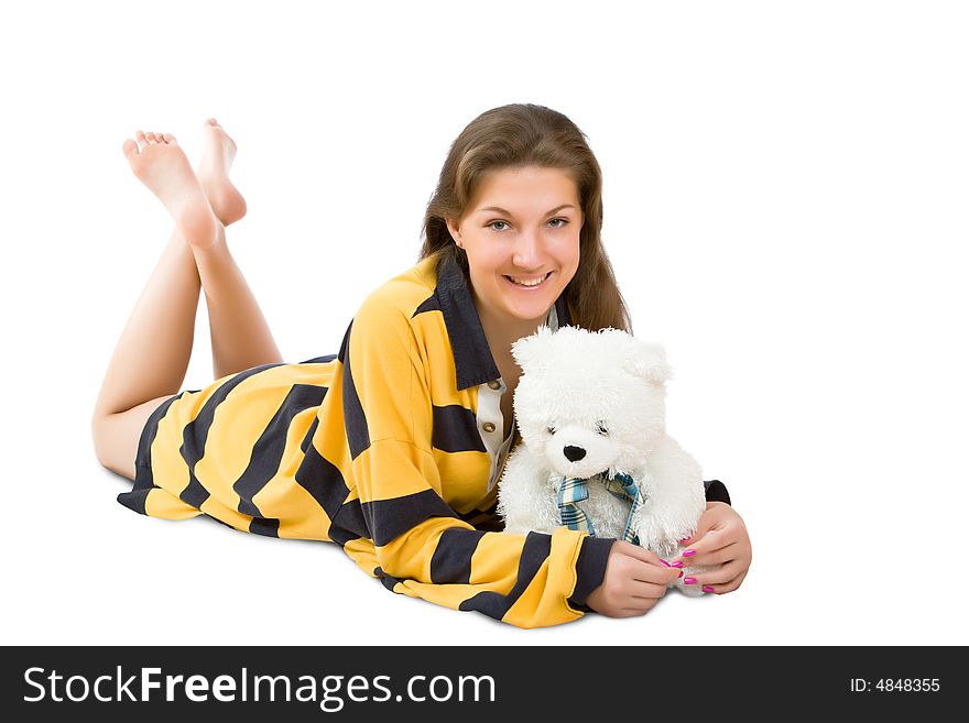 Attractive girl lays and embraces a toy bear isolated on a white background