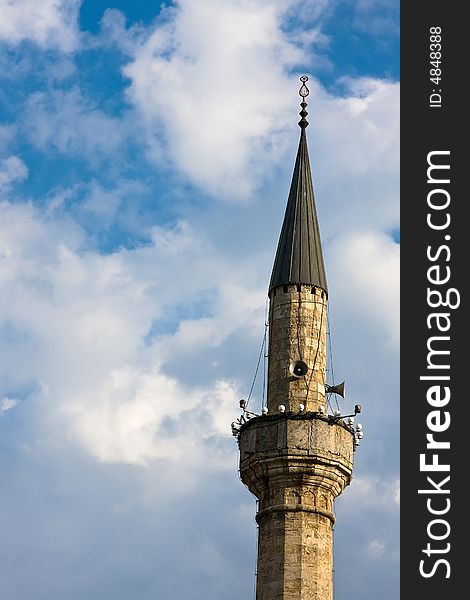 Single mosque minaret under the blue and cloudy sky