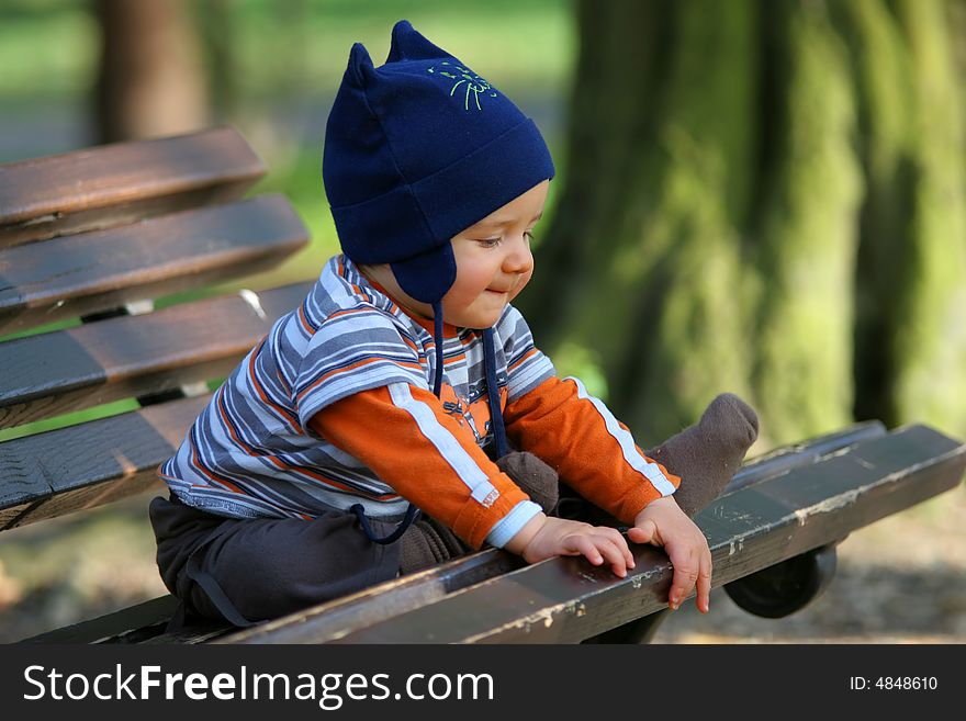 Baby sitting on the bench in the park