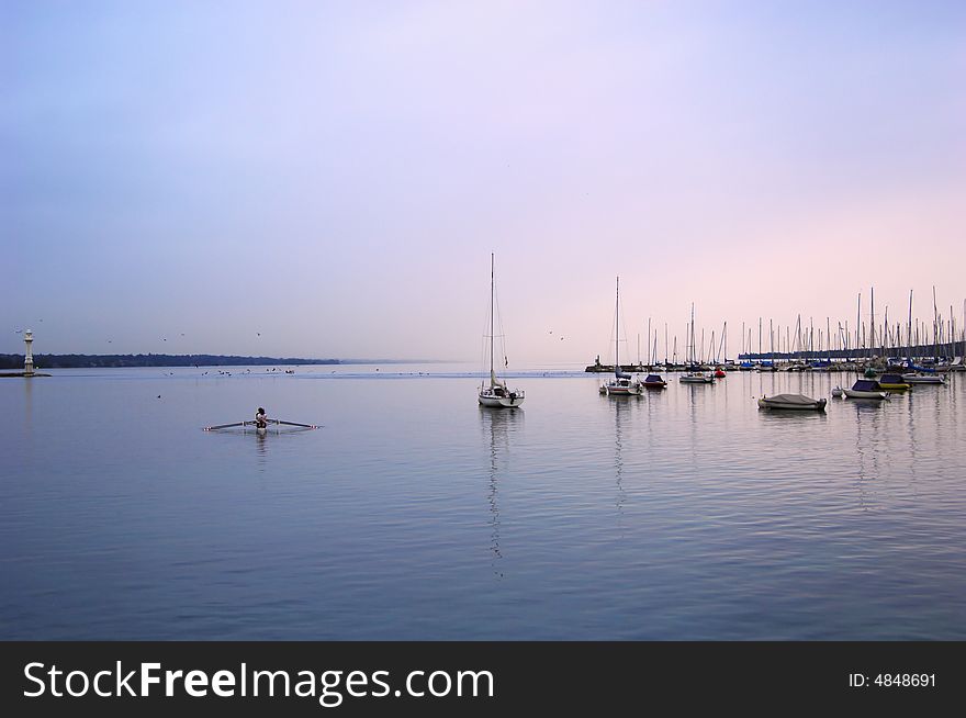 Sailboat lough in the morning, first sun rays, geneva lake, switzerland.