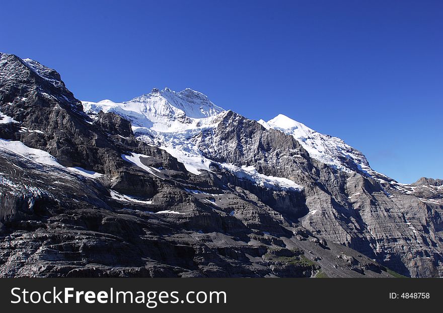The snow peak in Swiss Alps. blue sky background