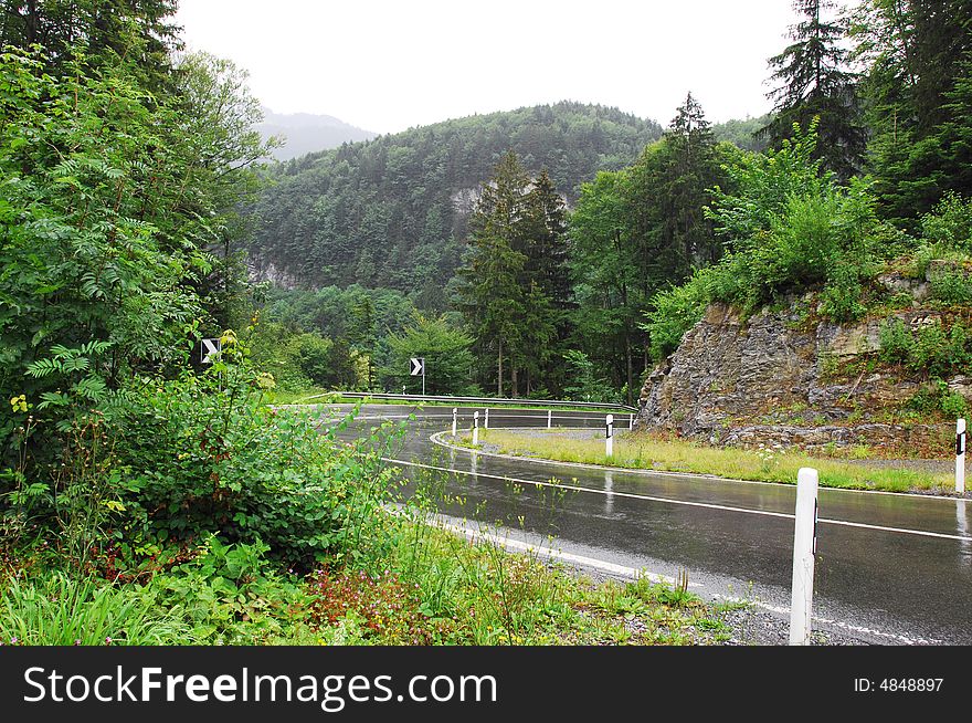 Winding road in mountain, blind bend，after rain, the road was wet。