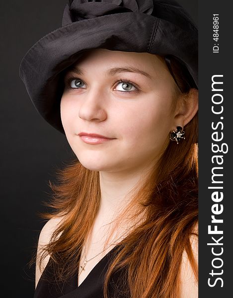 The charming young girl in studio on black background