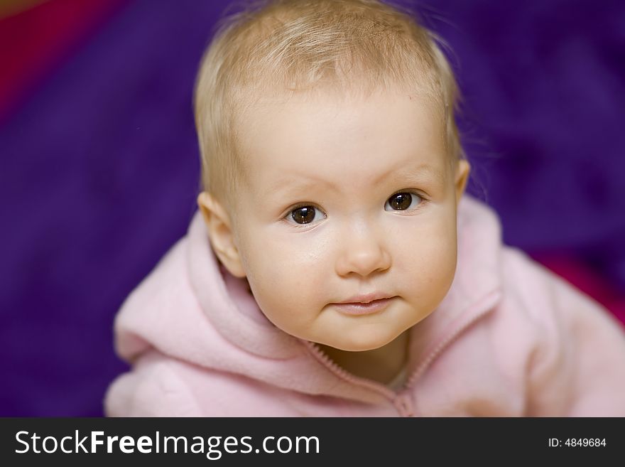 Young baby girl in pink blouse on blue background