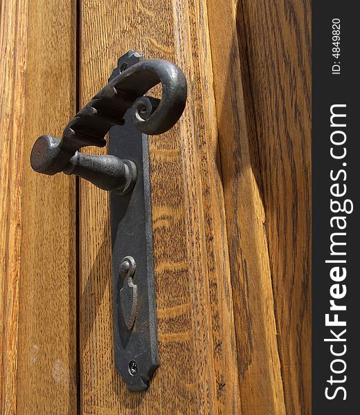 Antique door handle on the old wooden door. Antique door handle on the old wooden door