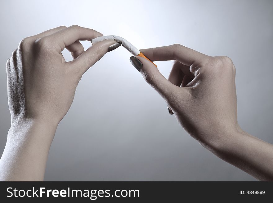 A female hands are breaking the cigarette