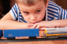 Boy Looks At Toy Railroad Stock Photo