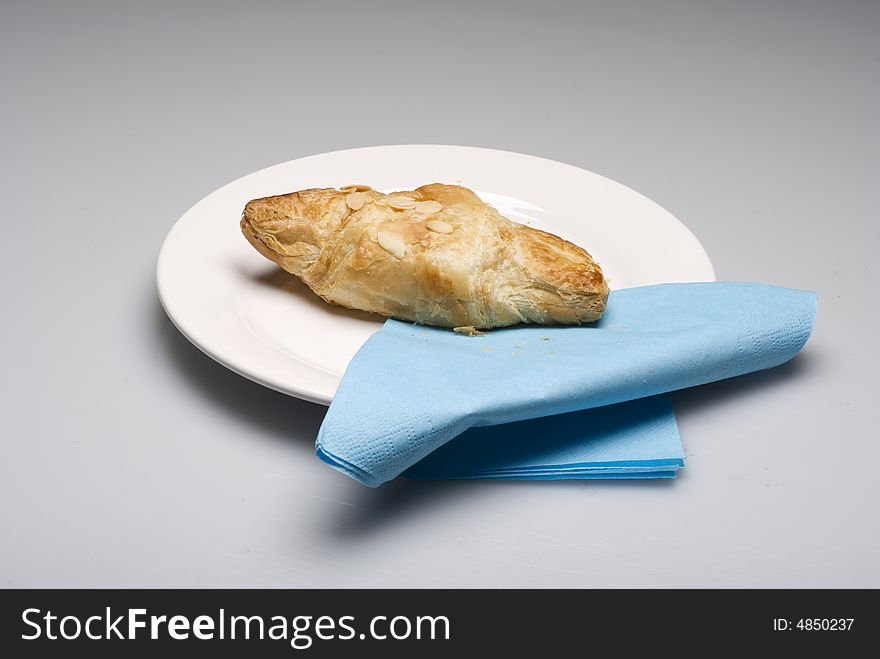 Croissants on a plate with a blue tissue