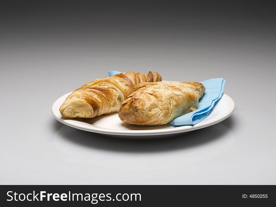 Croissants on a plate with a blue tissue