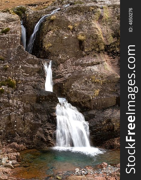 A landscape photo of a waterfall in Glencoe, Scotland