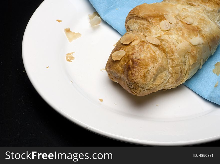 Croissants on a plate with a blue tissue isolated on black background