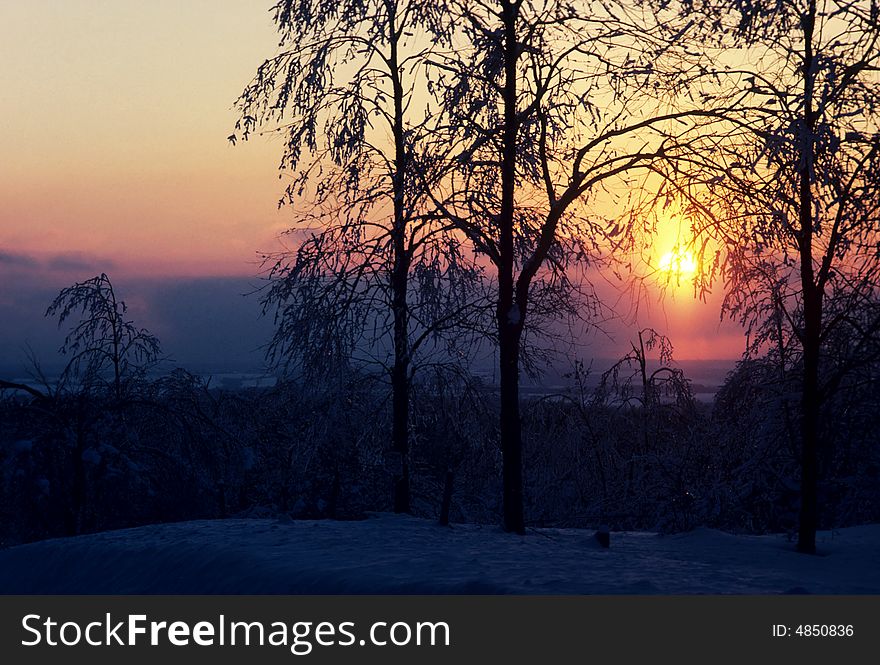 The sun sets on a frozen field. The sun sets on a frozen field