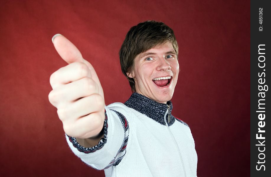 The young happy man with thumb up