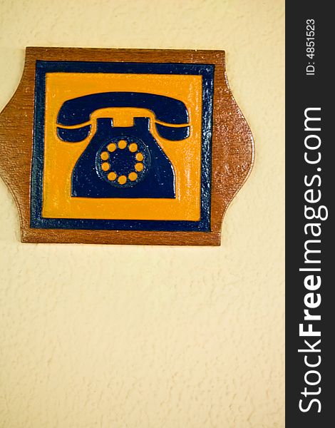 A Telephone Sign Carved Out Of Wood