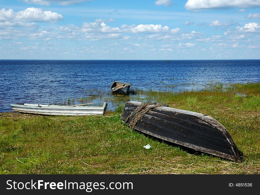 Three old fishing wooden boats on the lake bank in north Russia. Three old fishing wooden boats on the lake bank in north Russia
