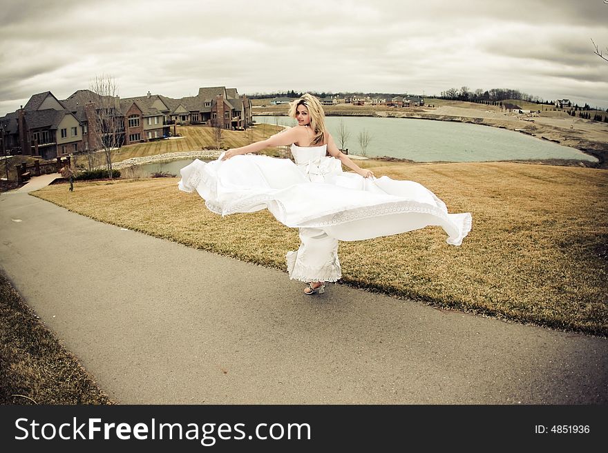 Runaway bride in the field during a stormy windy day. Runaway bride in the field during a stormy windy day