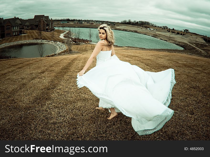 Runaway bride in the field during a stormy windy day. Runaway bride in the field during a stormy windy day