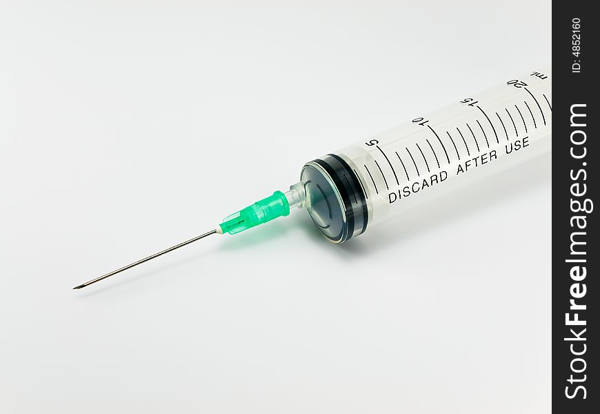 Syringe with hypodermic needle against white background