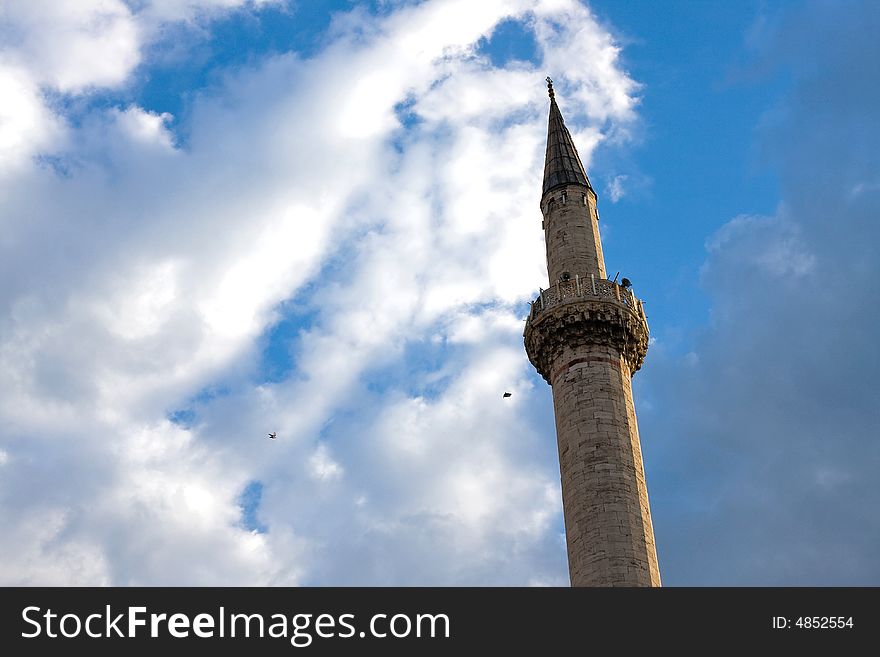 Single mosque minaret under the blue and cloudy sky