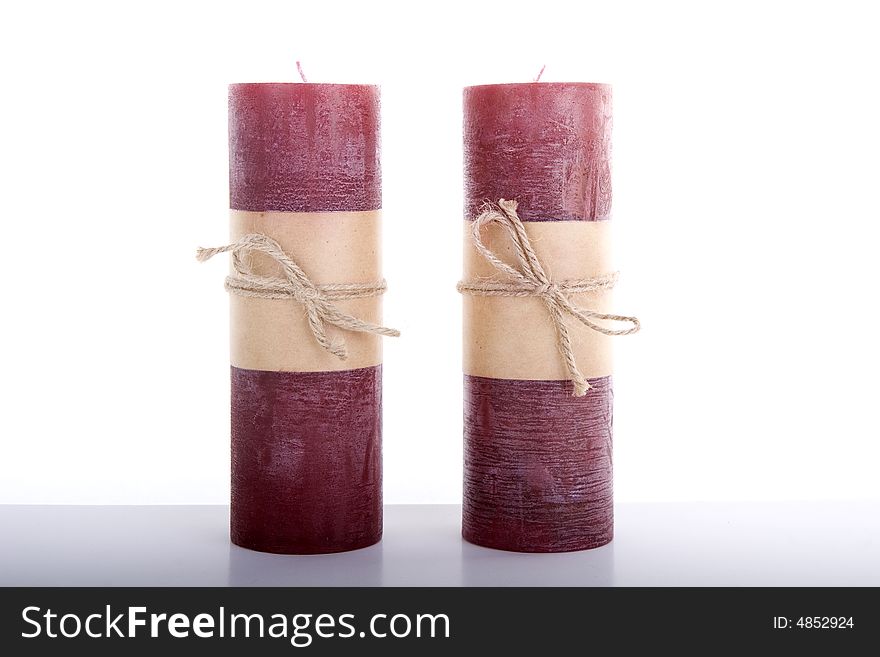 Red Christmas Candles tied with string on a white table against a white background. Red Christmas Candles tied with string on a white table against a white background